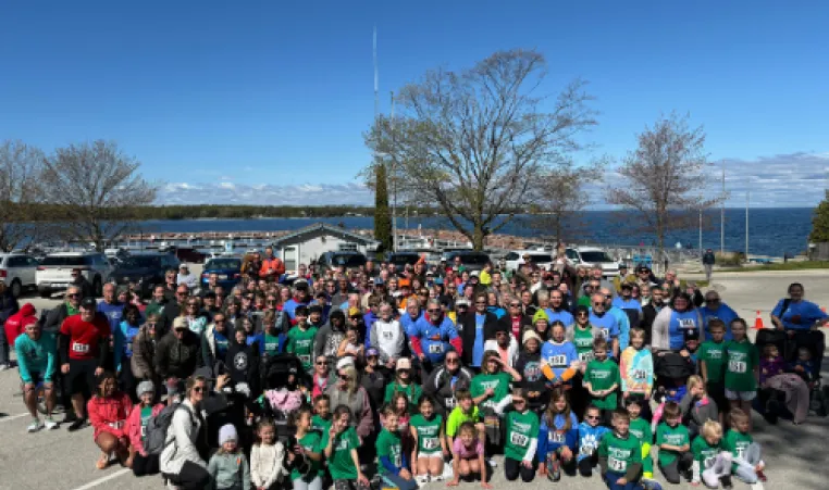 A group picture of the 2024 Blossom Run participants in the Dock View/Marina Park parking lot
